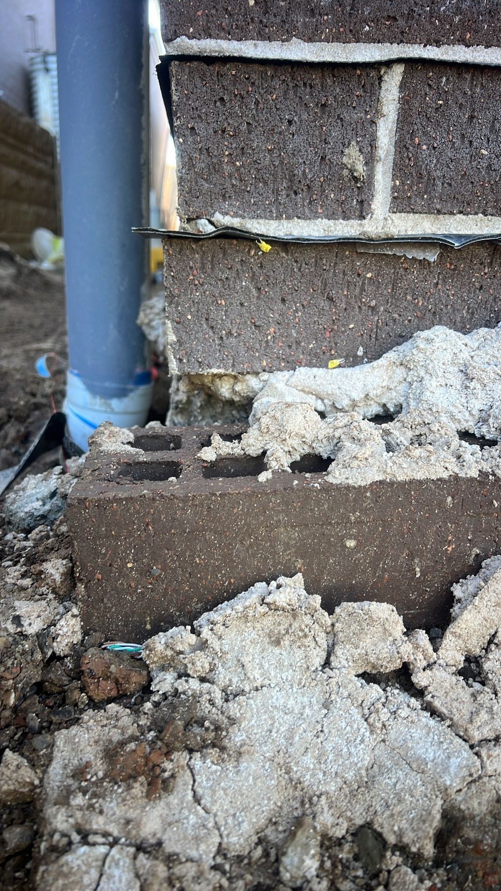 Brick face projecting over 15mm past the Cobbitty slab edge, found during a handover inspection in Cobbitty