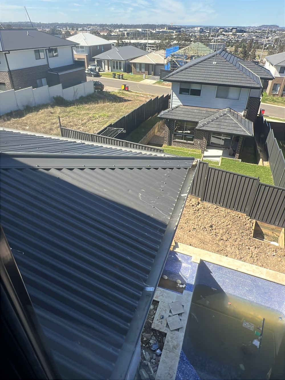 Metal roof sheeting dented and scratched in several places, found during a handover inspection in Cobbitty